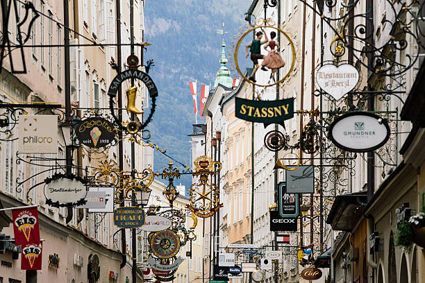 straße getreidegasse mit mehreren werbeschildern, salzburg - salzburg stock-fotos und bilder