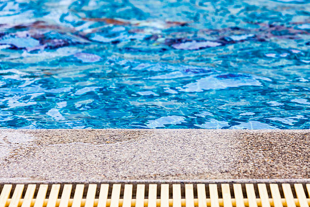istock Pool edge with blue water and the overflow drain 628319828