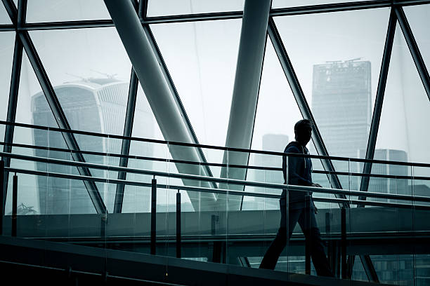 uomo d'affari che scende le scale con lo skyline di londra sullo sfondo - people traveling abstract glass men foto e immagini stock