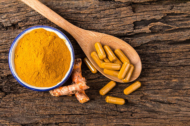 turmeric powder , capsule and roots curcumin on wooden plate stock photo
