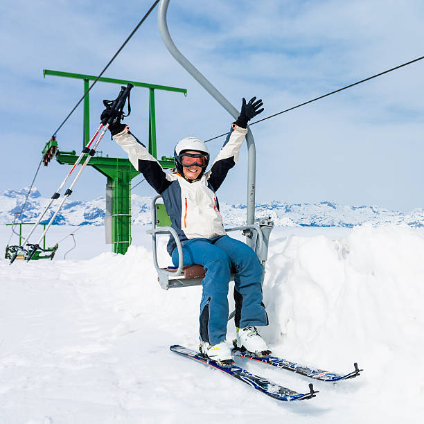 istock Happy female skier riding a lift. 628331336