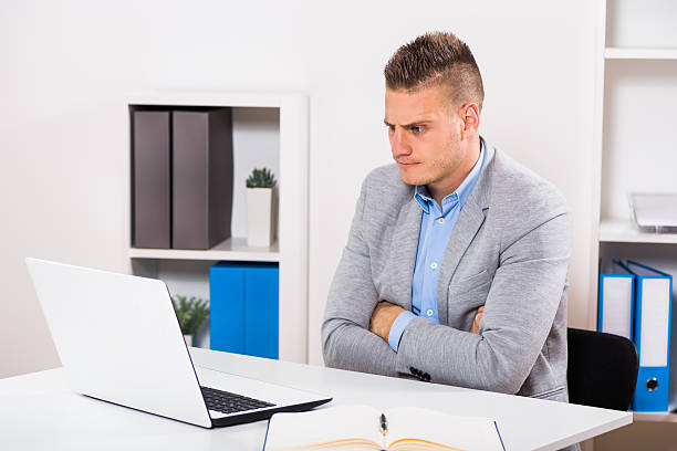 istock Angry businessman looking at his laptop 628332520