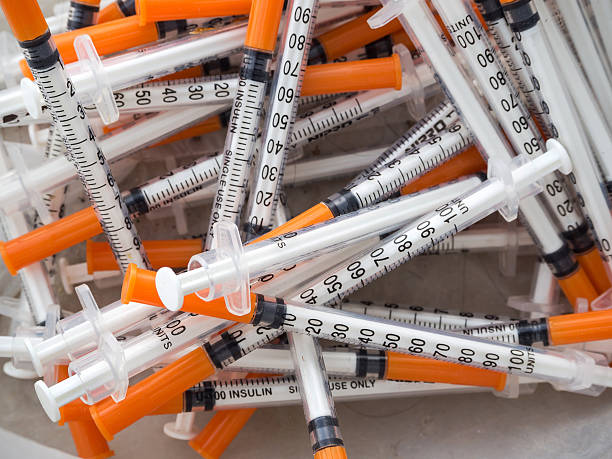 Close up of used syringes in the trash stock photo