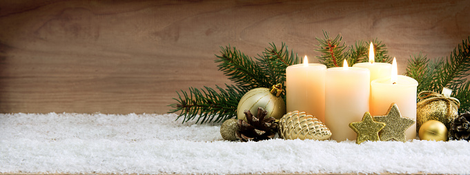 Christmas background with four white advent candles and golden decoration.