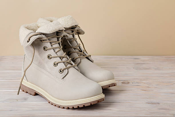 istock Bright leather winter boots on a light wooden background. 628345838