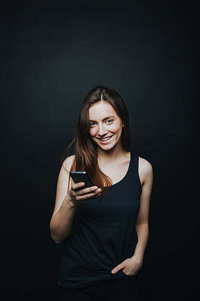 istock Young pretty woman posing with smartphone 628346124