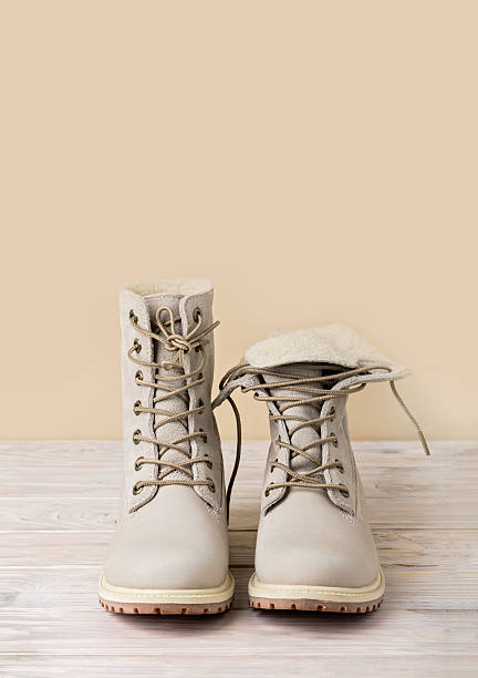 istock Bright leather winter boots on a light wooden background. 628347012