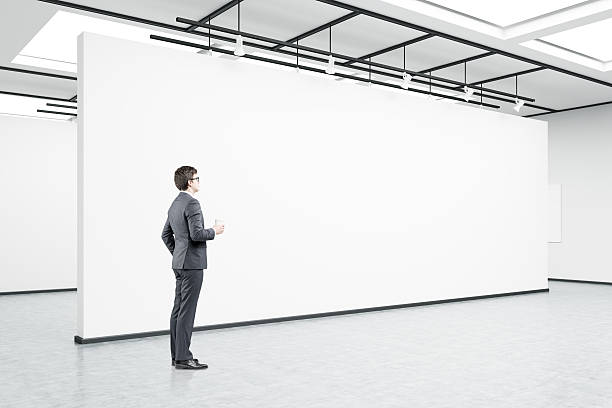 istock Man in glasses with coffee in an art gallery 628349768