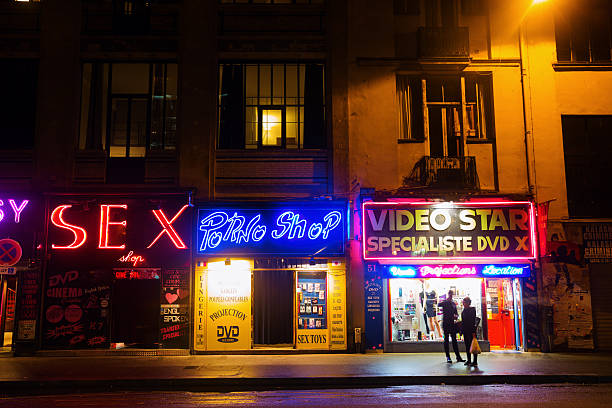 night scene in Pigalle district, Paris, France Paris, France - October 20, 2016: night scene in Pigalle district, with unidentified people. Pigalle is famous for being a tourist district with many sex shops theatres and adult shows on Place Pigalle and the main boulevards place pigalle stock pictures, royalty-free photos & images