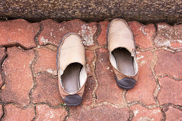 istock Old brown male shoes on cement block floor background 628357800