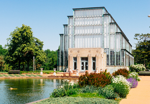 St. Louis, United States - May 6, 2016: The landmark Art Deco building, the Jewel Box, is a horticultural greenhouse within Forest Park. Built in the 1930s, it is registered as a historic place. In the spring, blooming flowers are landscaped around the entrance. 