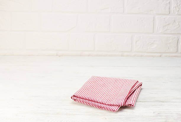 istock Red napkin isolated on white wooden table. Copy space. Brick 628360418