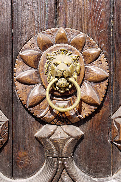 istock Lion head, Door knocker on wooden door 628364438