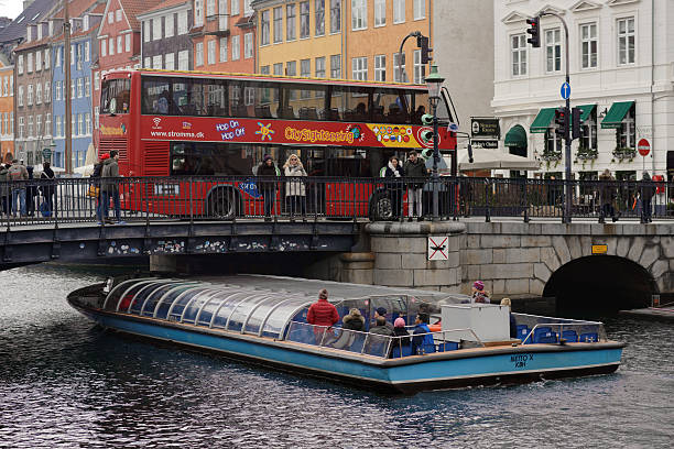 Copenhagen, Denmark - November 5, 2016: Sightseeing bus and tour boat at Nyhavn bridge. Nyhavn is one of the most popular tourist districts in the Danish capital city