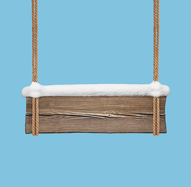 Wide wooden signboard with snow hanging on double ropes
