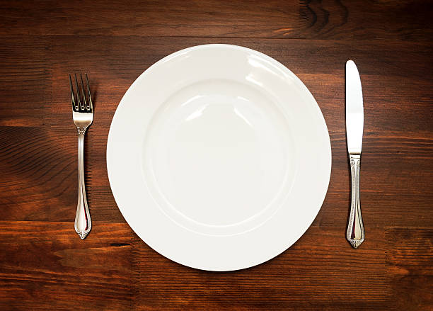 istock White plate with fork and knife on wooden table 628366680