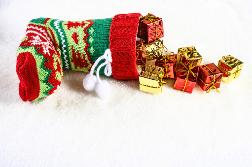 Colorful christmas stocking and lots of presents. On textural white background.