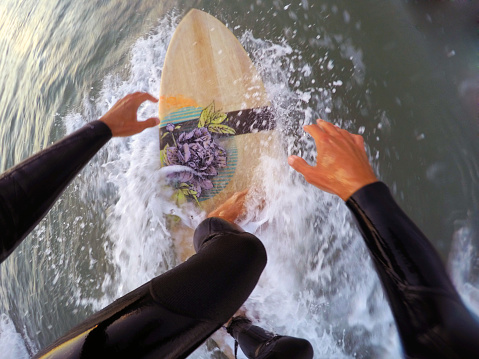 Surfing on a wooden surfboard (point of view)
