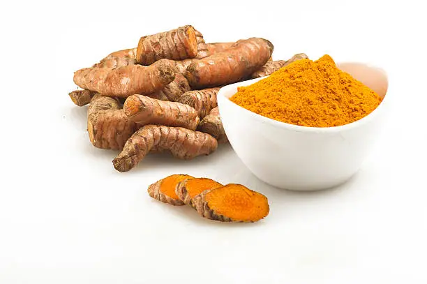 turmeric root and some slices on a white background