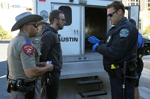Austin, Texas, USA - November 19, 2016: Texas Department of Public Safety troopers arrest a counter-demonstrator for assault during a 'White Lives Matter' demonstration just south of the Capitol. The 'White Lives Matter' demonstrators, numbering about 20 people at the most, came from Houston with the message that the federal hate crime law is unfair to white people.