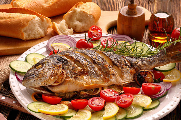 istock Grilled fish with baguette and vegetables on the plate 628390212