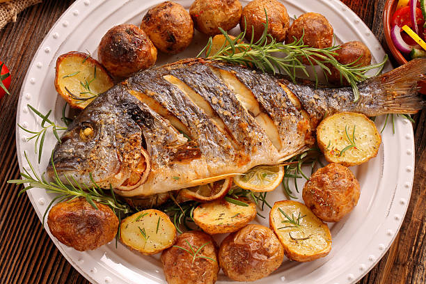istock Grilled fish with roasted potatoes and vegetables on the plate 628390322