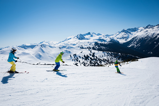 Family skiing surrounde3d by stunning mountain views