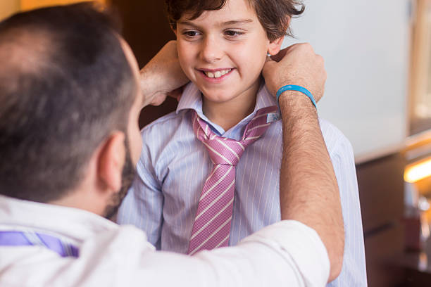 istock Father is helping his son to wear the tie. 628408162