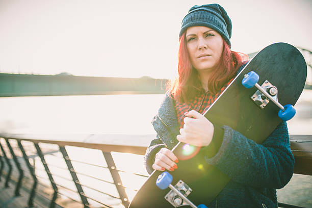 istock Young woman with skating board on the riverside 628408762