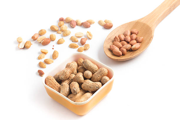 pilha de amendoins. sementes de concha em uma colher - peanut nut snack isolated - fotografias e filmes do acervo