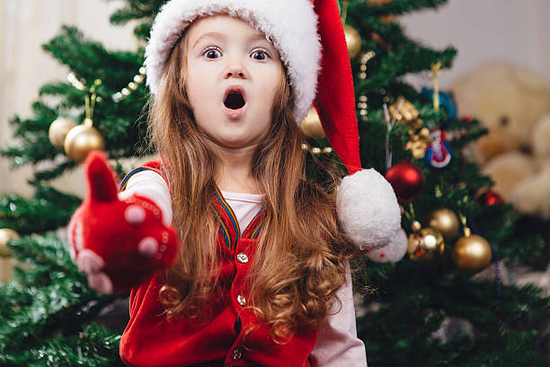 istock Surprised cheerful girl in red christmas hat 628410902