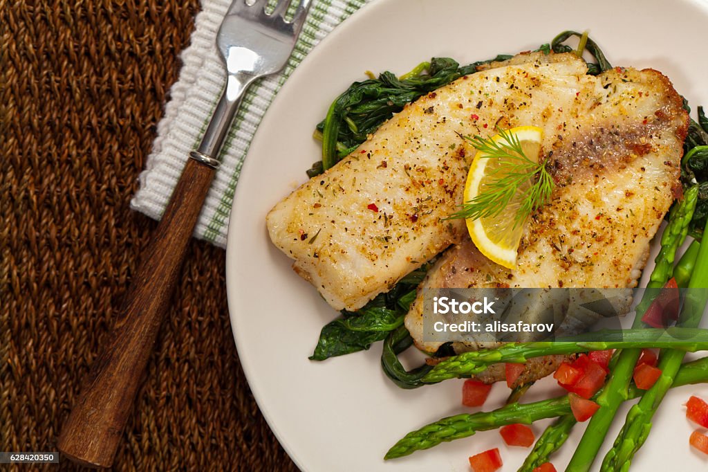 Baked Fish Fillet Whitefish with Roasted Asparagus. Selective focus. Tilapia Stock Photo