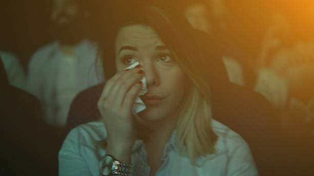 Women crying while watching movie in a cinema hall Young couple at the cinema watching movie wiping tears stock pictures, royalty-free photos & images