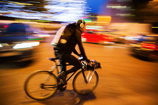 cycle courier in paris, france, at night - bicycle messenger imagens e fotografias de stock