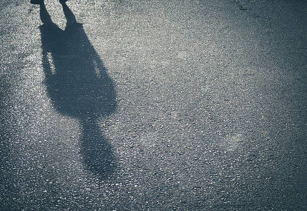 sombra de un hombre sobre fondo callejero - shadow focus on shadow people men fotografías e imágenes de stock