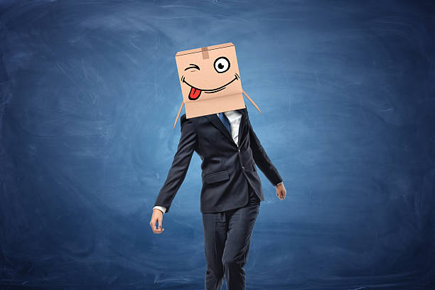 istock Businessman wearing cardboard box with drawn winking face on his 628433898