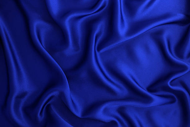 istock Close up wave  luxury blue silk or satin fabric background 628434124