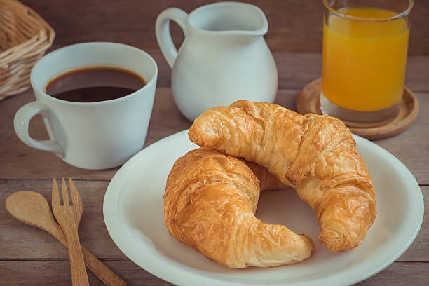 istock Croissants on plate with coffee cup and juice 628434440