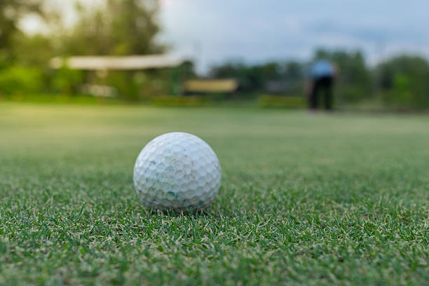 istock Golf ball on green and Golf player 628434948