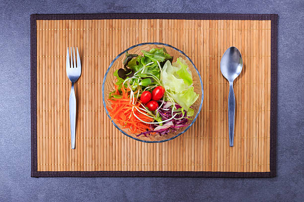istock fresh salad bowl with spoon and fork on bamboo mat 628438912