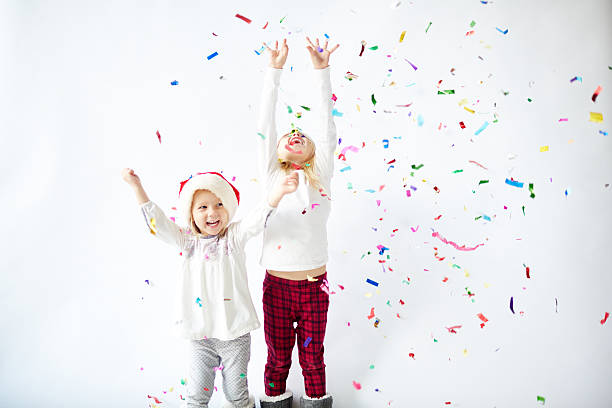 istock Happy little sisters enjoying confetti falling on Christmas party 628441474