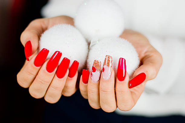 red nails decorated for your fantastic Christmas nails decorated with red, Christmas decorations and golden hues to celebrate your fantastic Christmas and New Year's party christmas nails stock pictures, royalty-free photos & images
