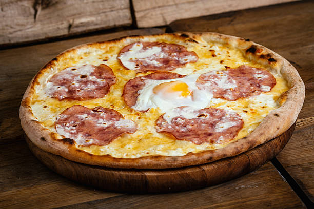 istock Pizza with ham and egg on wood background 628452788