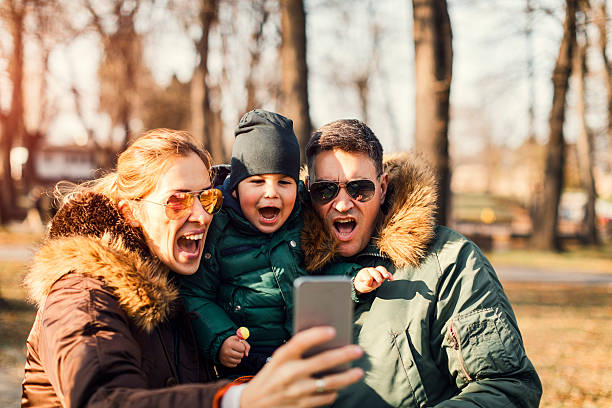 istock Happy Family Walks In The Park Making Selfie 628453480