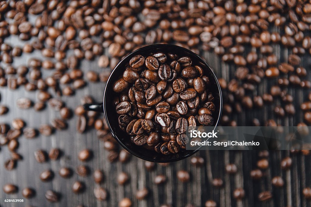Coffee cup and  beans on wooden background. Top view. Close-up coffee cup and coffee beans on wooden background. Top view. Coffee Roaster Stock Photo