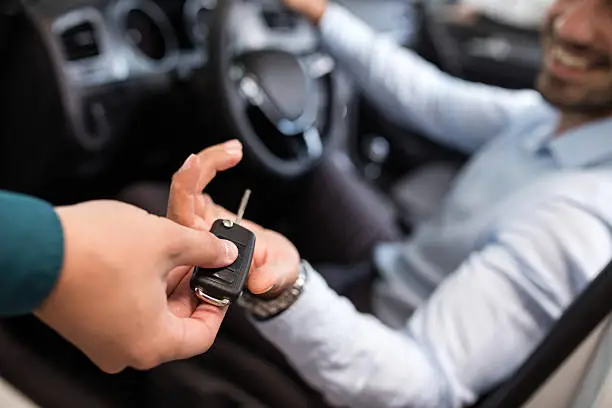 Photo of Close up of a man receiving new car key.
