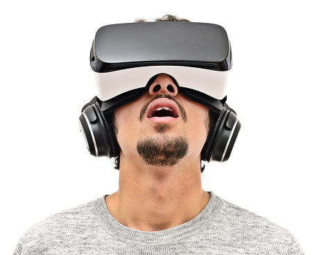 Young man wearing vr headset and handphones. Isolated on white. Wearable technology concept. 