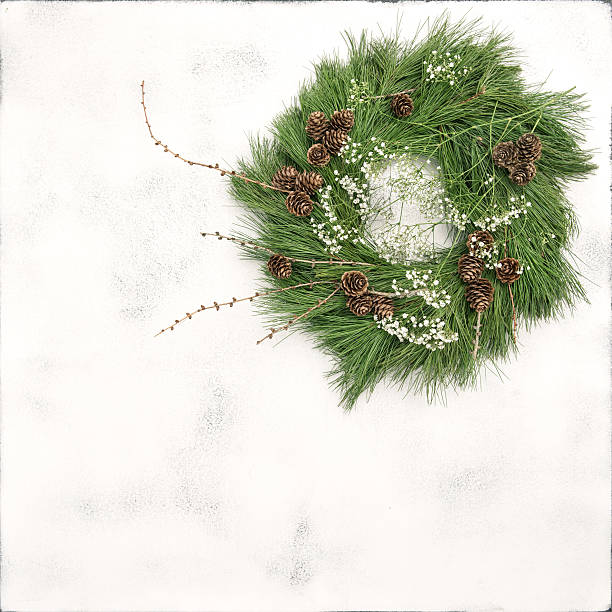 istock Christmas wreath pine cones white flowers stone background 628464234