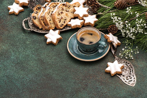 Traditional Christmas cake Stollen, cookies, coffee and decoration. Holidays food background