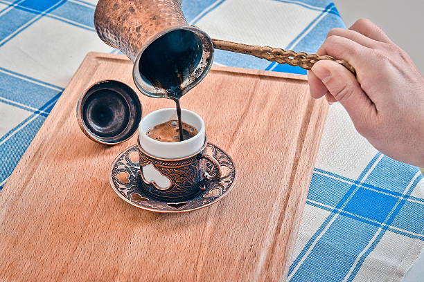 istock Pouring turkish coffee into traditional embossed metal cup 628469942